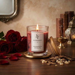Sovaré Velvet Rose & Oud scented candle in a clear glass jar with a gold coaster and red wax.