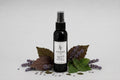 Sovaré Lavender & Patchouli Room Spray bottle, dark glass, surrounded by lavender sprigs.